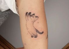 a small cat tattoo on the arm