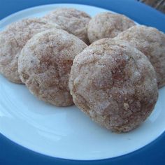 four powdered sugar cookies on a white plate