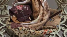 a close up of a scarf on top of a metal chair with floral print fabric