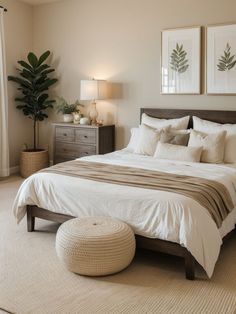 a bedroom with a large bed and two pictures on the wall