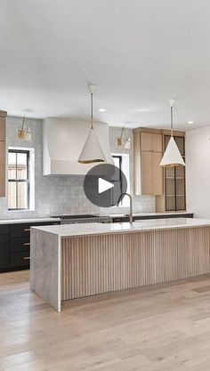 a kitchen with an island in the middle of it and lots of cabinets on both sides