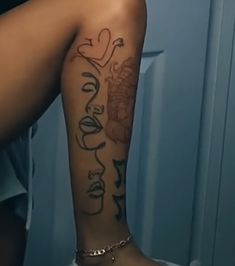 a woman's arm with tattoos on it and writing on the side of her leg