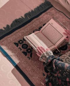 a person reading a book on top of a rug