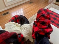 a child's feet in the middle of a pile of blankets on the floor