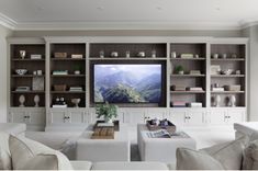 a living room filled with white furniture and a flat screen tv mounted on a wall