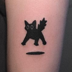 a small black cat tattoo on the arm