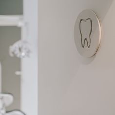 a toothbrush is mounted on the wall next to a sink in a room with white walls