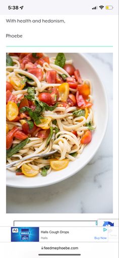 a plate of pasta with tomatoes and spinach on the side next to an instagram page