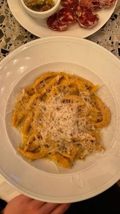 two plates with pasta and meat on them