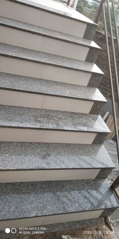 an image of some stairs that are made out of concrete and granite slabs with metal handrails