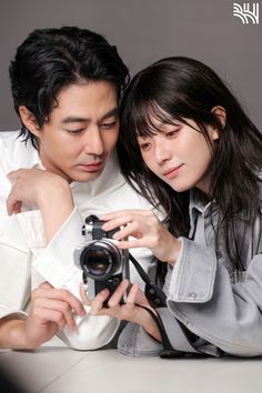 a man and woman taking a photo with a camera