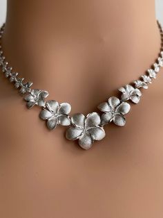 Elegant and Beautiful 14Kt Solid White Gold Hawaiian Graduated 20mm, 17mm, 13mm, 10mm, 8mm Plumeria Flower Lei Necklace Diamond Cut on the edges of each petals. 14K Solid Gold GUARANTEED, Authenticated with a 14K Stamp Made with Highest Quality Craftsmanship Solid 14K White Gold Graduated Plumeria Lei Necklace Length approximately 17 Inches Total Weight 22.6 grams Solid 14K White Gold Hawaiian Graduated Plumeria flowers Width 20 Millimeters One Plumeria flower Width 17 Millimeters Two Plumeria f Elegant Engraved Flower Necklace, Formal Flower-shaped Engraved Jewelry, Formal Engraved Flower Jewelry, Plumeria Lei, Flower Lei, Plumeria Flowers, Necklace Diamond, Wedding Jewellery Necklace, Elegant Necklaces