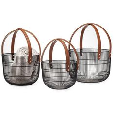 three black and white baskets with leather handles, one is holding two balls in it