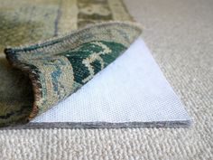 an area rug is laying on the floor next to a piece of carpet that has been rolled over