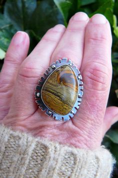 Made with a 18x24 mm natural, painted jasper cabochon, this ring reminds me of Western fields and open roads. The sandy colored gem sits on a 25x34mm base that is adorned with an unique pattern and sterling silver beads. The gem is wrapped in fine silver (.999) and sits on a sterling silver (.925) base. The stone possesses hues of chocolate brown, golden brown and black. The piece has been oxidized and lightly polished giving it great contrast and an industrial vibe. The piece is weighty and ric Unique Jasper Ring Jewelry, Handmade Jasper Rings As Gift, Handmade Jasper Rings As A Gift, Handmade Jasper Rings For Gift, Unique Jasper Rings For Gift, Southwestern Jasper Jewelry Gift, Desert Jasper, Open Roads, Painted Desert