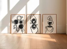 three black and white drawings are on the wall next to each other in an empty room