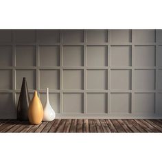 three vases sitting on top of a wooden floor in front of a gray wall