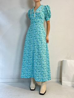 "- Vintage handmade blue floral peasant dress - Zipper and ties at the back - Feels like a thick polyester - No tags - Small  Bust: 19\" Waist: 15.5\" Length: 53\"" Green Floral Print Puff Sleeve Maxi Dress, Green Puff Sleeve Maxi Dress With Floral Print, Blue Ditsy Floral Print Maxi Dress For Garden Party, Casual Blue Floral Dress With Square Neck, Blue Ditsy Floral Print Short Sleeve Maxi Dress, Blue Puff Sleeve Maxi Dress For Summer, Blue Floral Print Dress With Square Neck, Casual Blue Puff Sleeve Maxi Dress, Light Blue Floral Print Dress With Square Neck