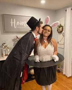 a man and woman dressed up as rabbits kissing on the cheek while standing next to each other