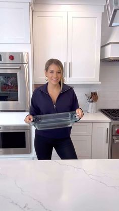 a woman is holding a baking pan in her hands