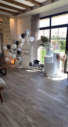 a room filled with balloons and decorations on top of hard wood flooring next to a large window