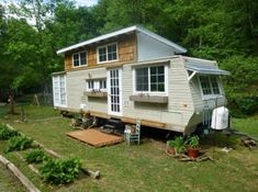 a mobile home is shown in the middle of a yard with lots of trees around it