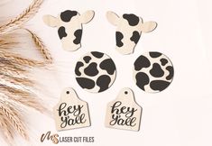 four wooden tags with black and white cow print on them, one has the word hey giraffe