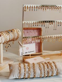 gold jewelry is displayed on display in a store with price tags attached to the chains