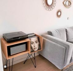 a living room with a couch, table and television on it's stand in front of a mirror