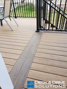 a deck and railing with chairs on it