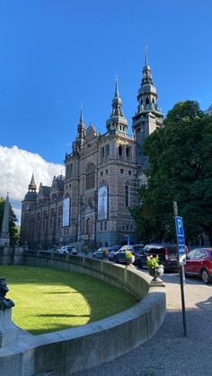 a large building with many towers on it's sides and cars parked in front