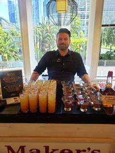 a man standing behind a counter filled with drinks