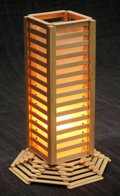 a tall wooden lantern sitting on top of a black floor next to a pile of logs