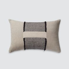 a black and white pillow with two contrasting stripes on the front, one in grey