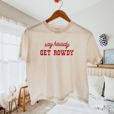 Say Howdy Get Rowdy Cropped Comfort Colors Shirt WOMEN'S COMFORT COLOR CROPPED BOXY TEE You can choose an oversize look or go with a regular fit. For an oversized cropped shirt fit, we recommend to size up by 2 - 3 sizes. If you are wanting a design change, please message the shop for approval - ANY design changes not approved by the shop will be cancelled SHIRT DETAILS - Comfort Colors® 3023 Women's Cropped Boxy Tee - 100% cotton, cropped, boxy fit - Runs true to size for a classic fit, if you Trending Tshirts Western, Aesthetic Cricut Shirts, Women Country Concert Outfits, Cute Vinyl Shirts, Cricut Tee Shirt Ideas, Cricut Shirt Ideas Women, Tee Shirt Outfit Ideas, Funny Country Shirts, Cute Sayings For Shirts