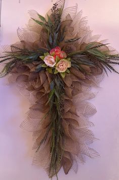 a wreath with flowers and greenery hanging on the wall