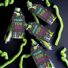 three bottles filled with green candy sitting on top of a black table next to each other