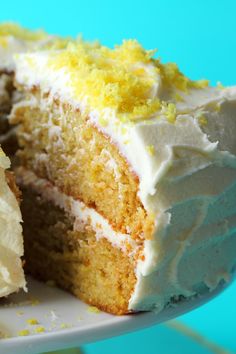 a close up of a slice of cake with white frosting and yellow sprinkles