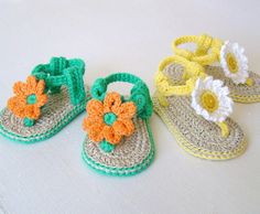 three crocheted sandals with flowers on them sitting next to each other, one is green and the other is yellow