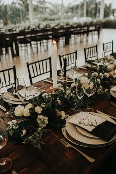 the table is set with white flowers and place settings for an elegant dinner or reception