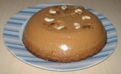 a chocolate cake with nuts on top sitting on a blue and white plate