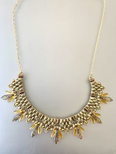 a gold necklace with lots of stones on it