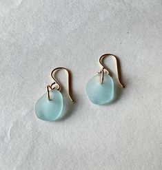 Gold sea glass jewelry Simple and elegant best describes these gold sea glass earrings.  The aqua color of the sea glass is so beautiful!  It emits the soothing calm and peace of the sea.  The simple design will enable you to wear them with any outfit.  The beautiful sea glass hangs from gold filled jump rings and gold filled ear wires.  What a perfect keepsake of the sea for a beach lover.  They would also be a stunning Christmas gift for her, that special woman in your life. Thank you for visiting my Etsy shop.  Be assured that these gold sea glass earrings were handcrafted with the highest quality of materials and with love. Your sea glass jewelry will arrive in an elegant silver gift box with a turquoise ribbon.  These earrings are ready to ship. Drop Earrings Gold, Silver Gift Box, Sea Glass Earrings, Jewelry Simple, Beach Lover, Beautiful Sea, Christmas Gift For Her, Women Christmas, Aqua Color