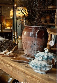 an old wooden table topped with vases and other items