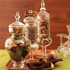 several glass vases filled with different types of candies and nuts on a tray