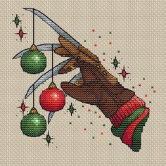 a cross stitch christmas card with an image of a hand holding a knife and balls