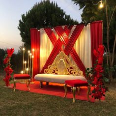 a decorated stage set up with red and white draping, candles and flowers