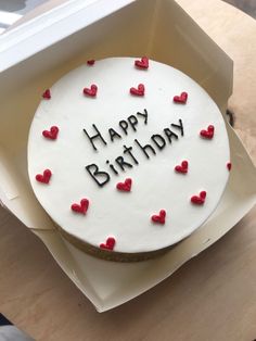 a white birthday cake with red hearts on it