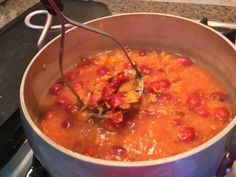 a large pot filled with lots of food on top of a stove next to a burner