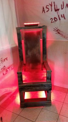 a chair made out of pallets with red light coming from the top and bottom